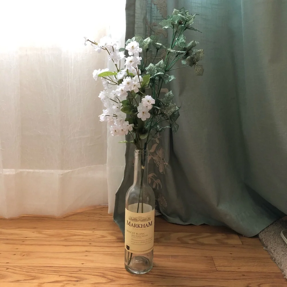 Faux floral with leaves in wine bottle